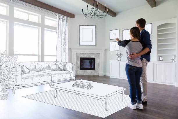 A young couple stand in the empty living room of their new home and imagine the room decor and furniture placement.